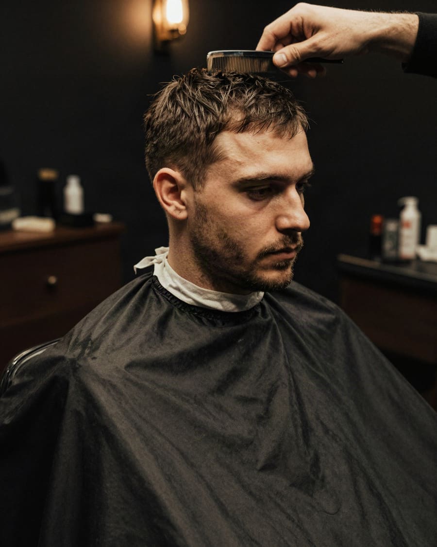 Barberare som klipper en kund i salongen